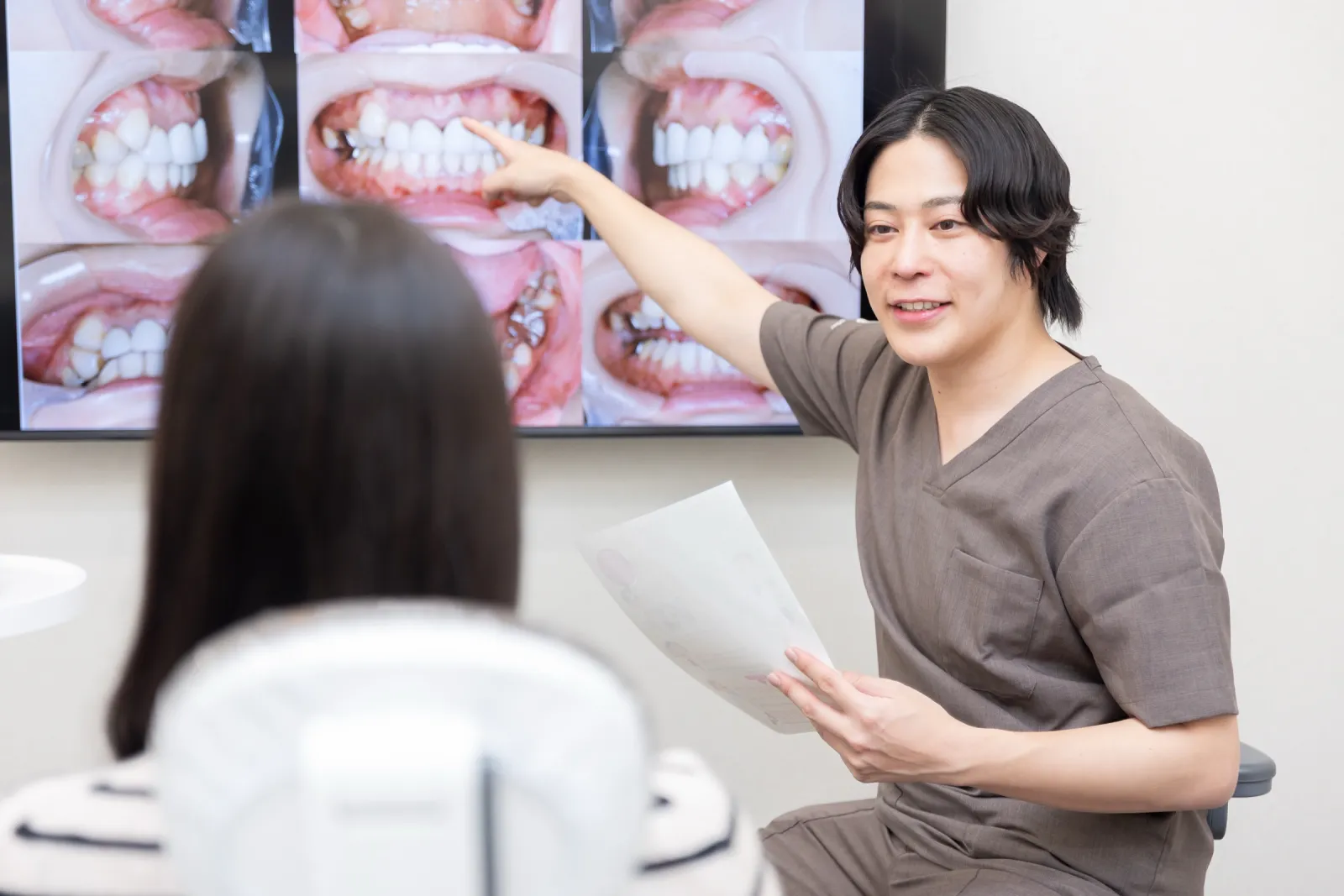 口腔内の写真を見せながら説明する院長